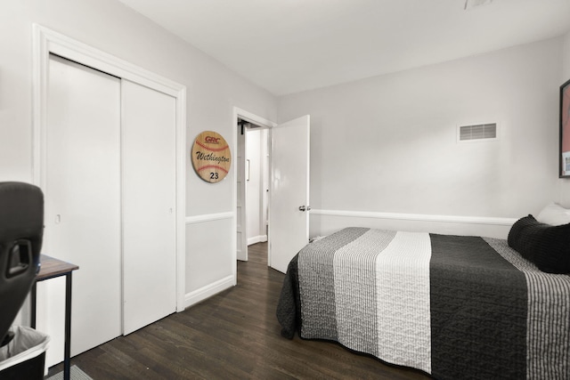 bedroom featuring wood finished floors, visible vents, a closet, and baseboards