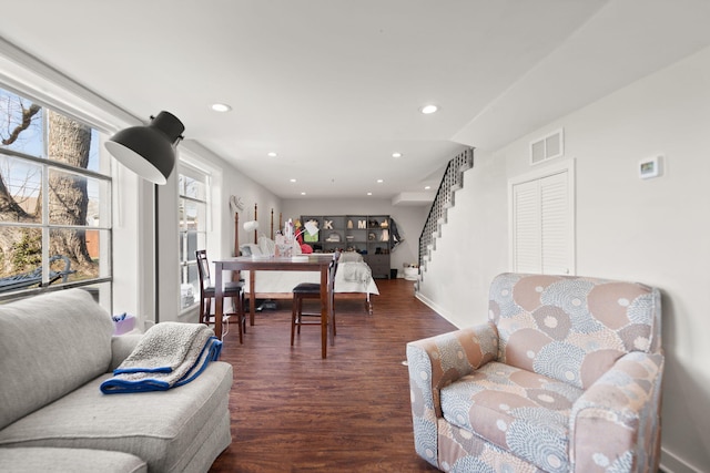 living area featuring visible vents, baseboards, stairs, recessed lighting, and wood finished floors