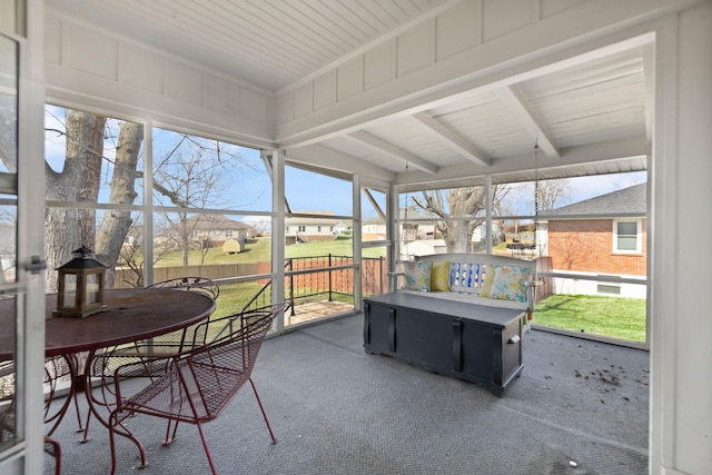 sunroom featuring beamed ceiling and plenty of natural light