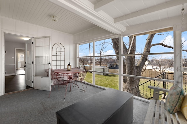 sunroom / solarium featuring beamed ceiling