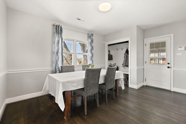 dining space with dark wood-style floors, visible vents, and baseboards