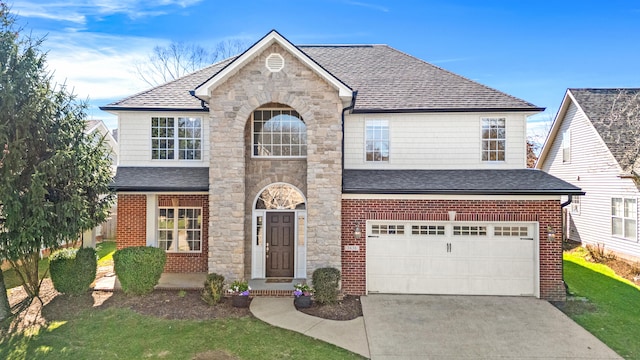 traditional-style house with an attached garage, a shingled roof, driveway, and stone siding