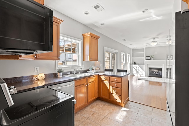 kitchen featuring ceiling fan, light tile patterned floors, electric range, a peninsula, and visible vents
