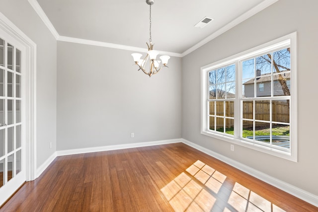 unfurnished dining area with a chandelier, baseboards, wood finished floors, and a healthy amount of sunlight
