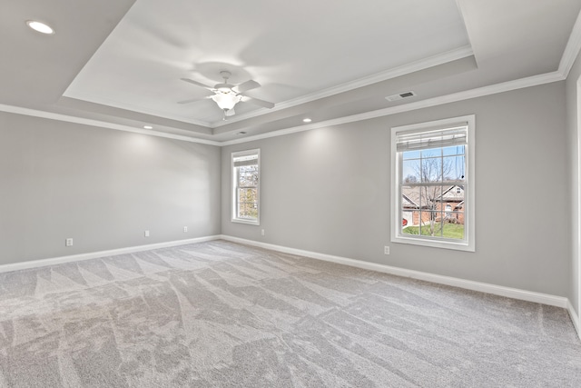 unfurnished room featuring a tray ceiling, visible vents, and plenty of natural light