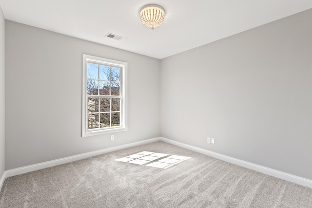 spare room featuring carpet flooring, baseboards, and visible vents