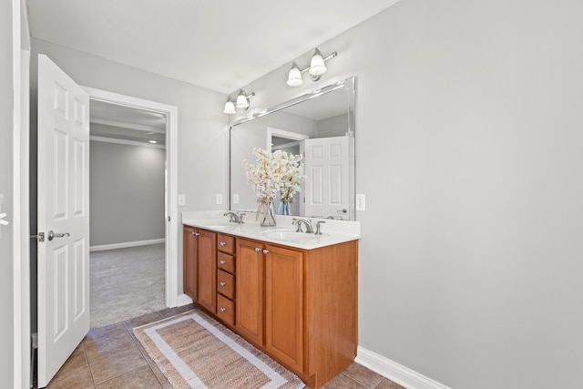 bathroom with tile patterned floors, double vanity, a sink, and baseboards