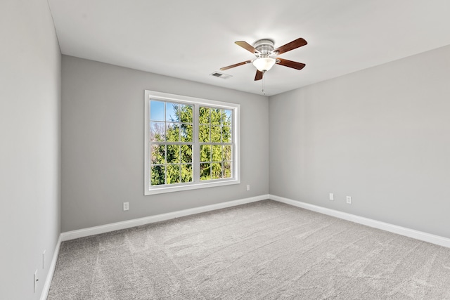 empty room with baseboards, a ceiling fan, visible vents, and carpet floors