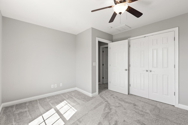 unfurnished bedroom featuring a closet, baseboards, carpet flooring, visible vents, and ceiling fan