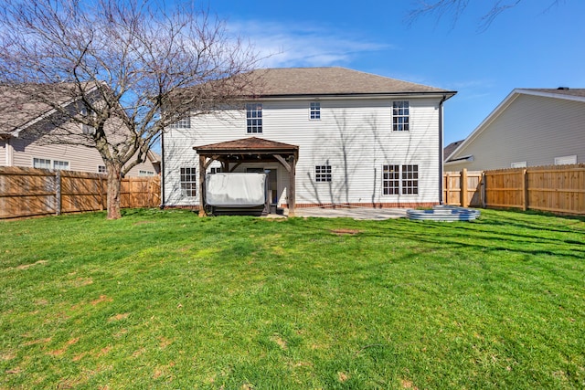 back of property featuring a gazebo, a fenced backyard, a patio area, and a lawn