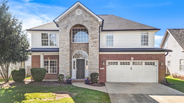 traditional-style home featuring concrete driveway, roof with shingles, stone siding, a front lawn, and an attached garage