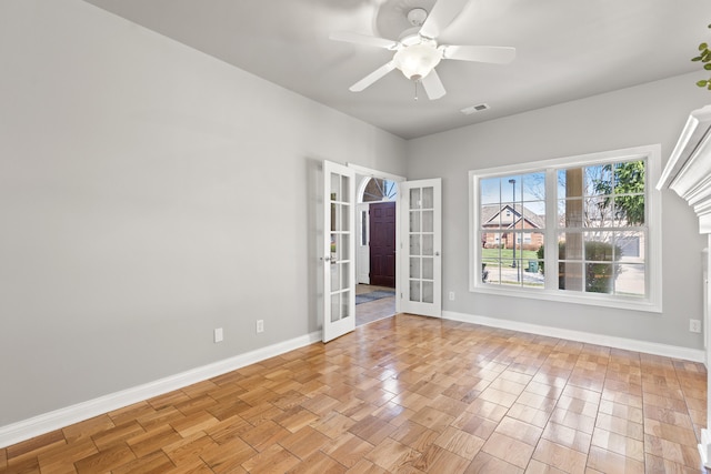 spare room with ceiling fan, light wood-style flooring, visible vents, french doors, and baseboards