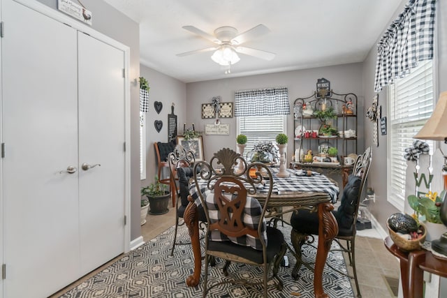 dining area featuring light tile patterned flooring, a healthy amount of sunlight, baseboards, and ceiling fan