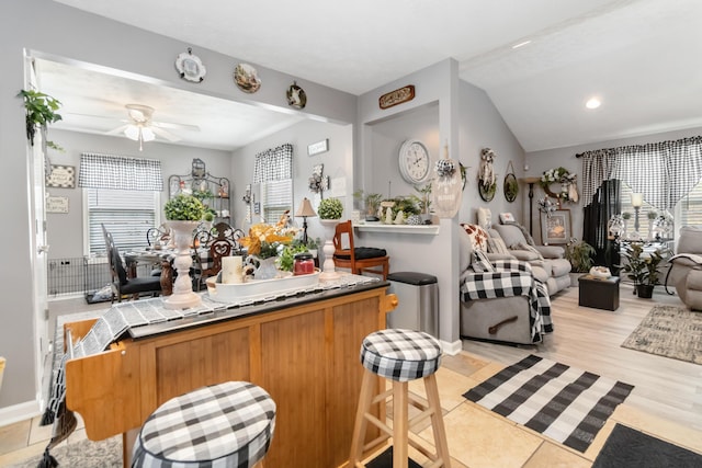 kitchen featuring brown cabinets, light wood-type flooring, open floor plan, and ceiling fan