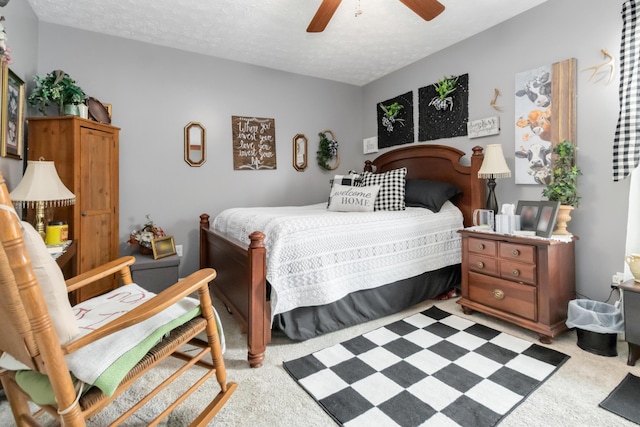 bedroom with light carpet, a ceiling fan, and a textured ceiling