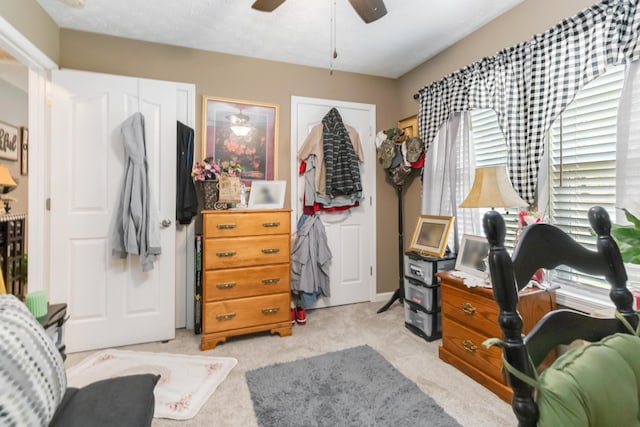 bedroom featuring light carpet and a ceiling fan