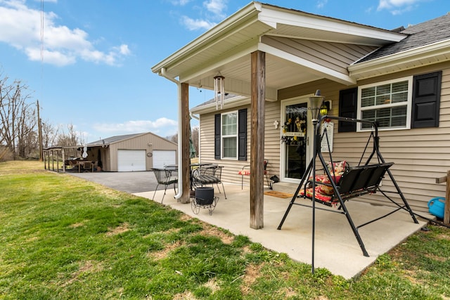 view of patio featuring a garage and an outbuilding