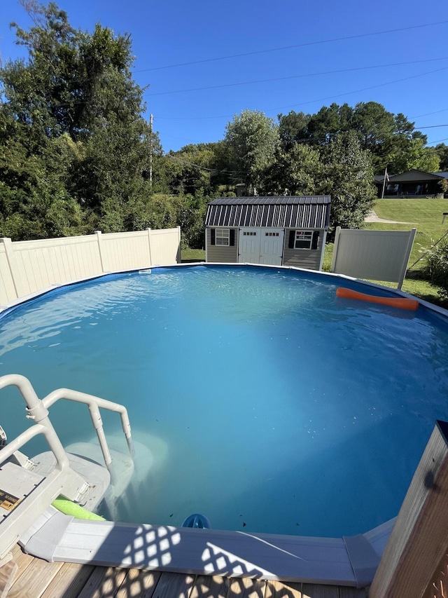 view of pool with an outbuilding, a fenced in pool, and fence