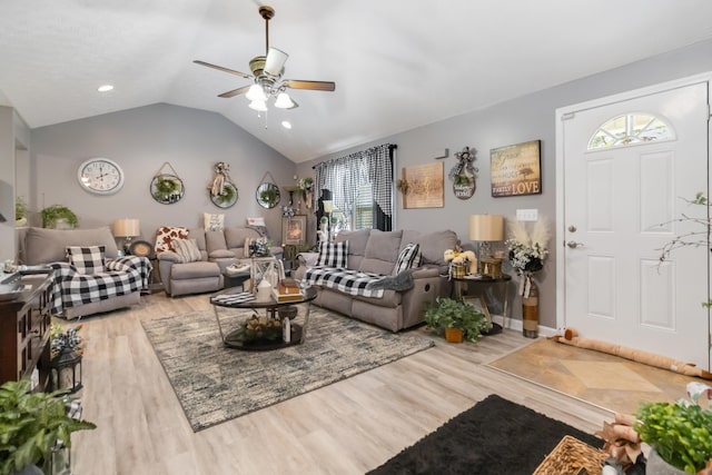 living area with vaulted ceiling, wood finished floors, a ceiling fan, and baseboards