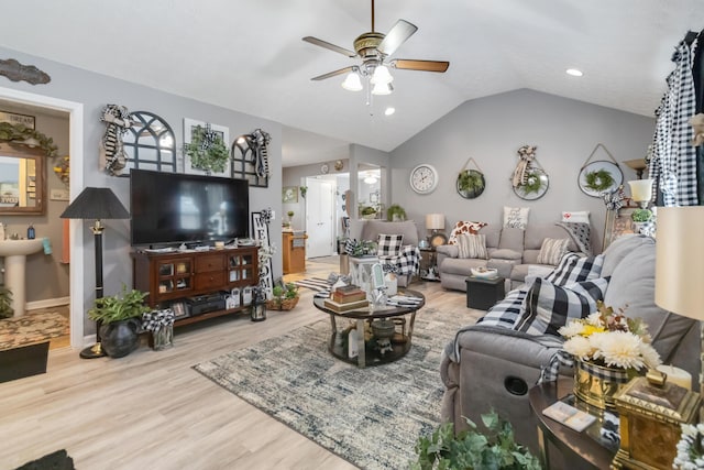 living area with baseboards, lofted ceiling, wood finished floors, and a ceiling fan