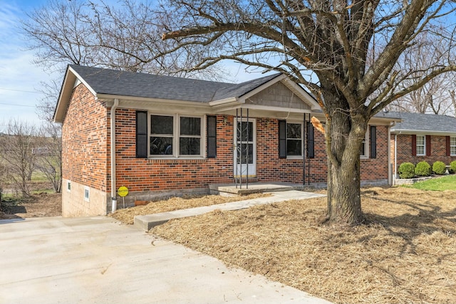 view of front facade featuring brick siding and roof with shingles