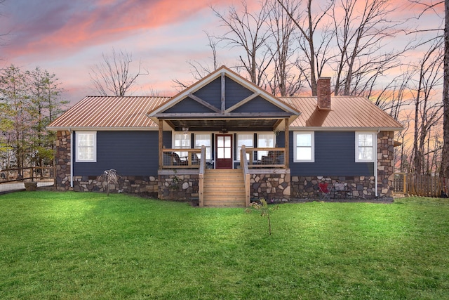 view of front facade with metal roof, a yard, and a porch