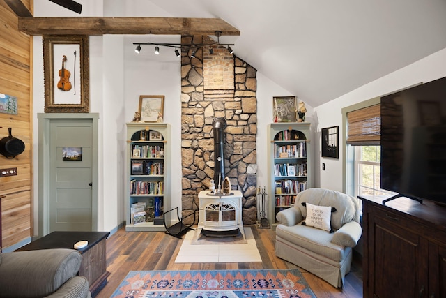 living area with vaulted ceiling, a wood stove, wooden walls, and wood finished floors