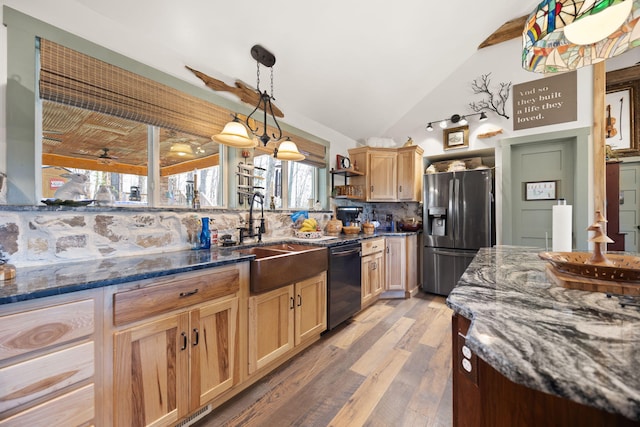 kitchen featuring dishwasher, vaulted ceiling, decorative backsplash, stainless steel refrigerator with ice dispenser, and a sink