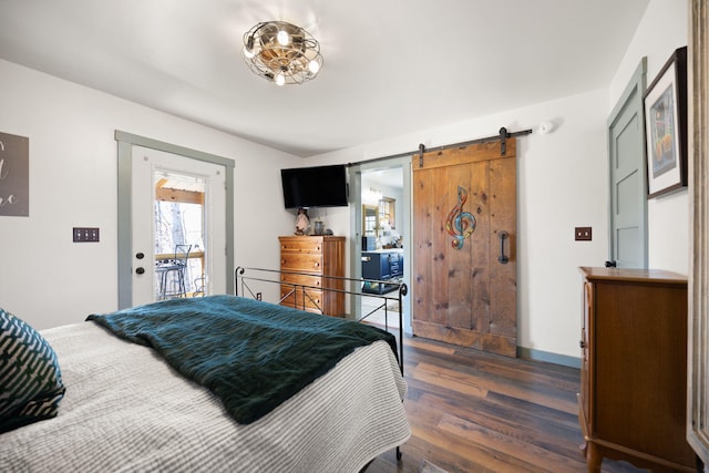 bedroom featuring dark wood-style floors, a barn door, and baseboards