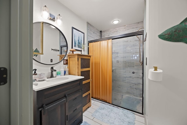 bathroom with tile patterned flooring, a shower stall, and vanity