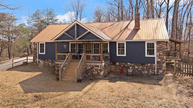 view of front of property with fence, a chimney, stairs, crawl space, and metal roof