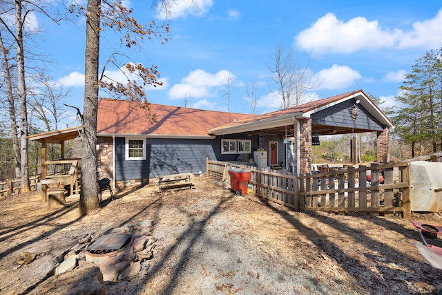 rear view of house featuring a porch and an outdoor fire pit