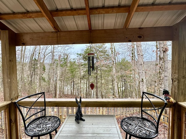 wooden terrace featuring a wooded view