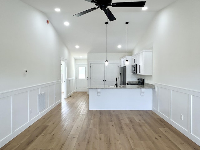 1403 Kit Cowan Rd, Somerset, KY 42503 - kitchen featuring stainless steel appliances, a ceiling fan, a peninsula, a decorative wall, and white cabinets