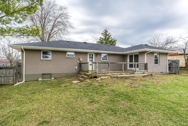 rear view of property with a wooden deck, fence, brick siding, and a lawn