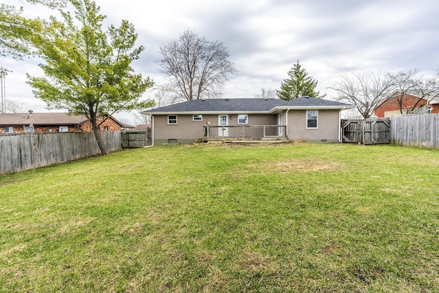 rear view of property featuring a deck, a lawn, a fenced backyard, and brick siding