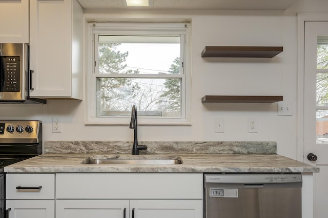 kitchen with open shelves, plenty of natural light, a sink, stainless steel appliances, and white cabinetry