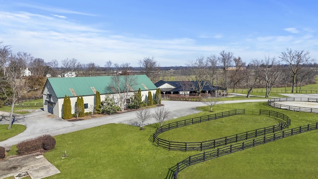 view of property's community with an enclosed area, a yard, fence, and curved driveway