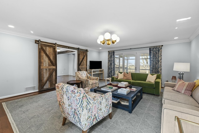 living area featuring a barn door, recessed lighting, visible vents, and ornamental molding