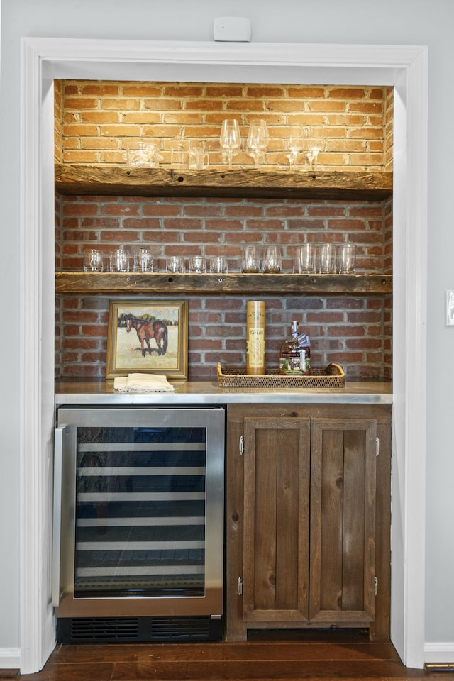 bar with wine cooler, a dry bar, and baseboards