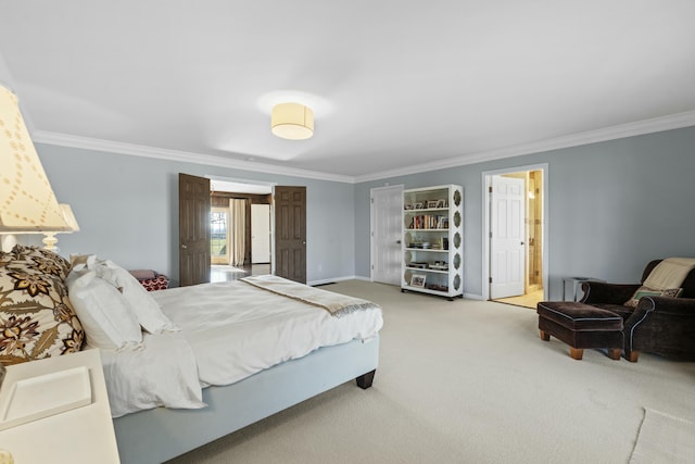 carpeted bedroom with baseboards, ensuite bathroom, and crown molding