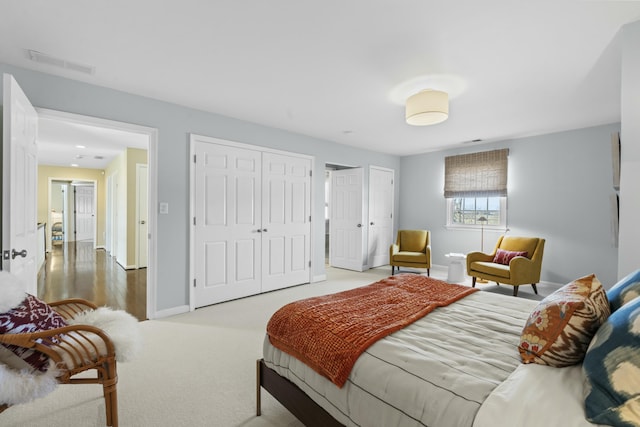 bedroom with baseboards, visible vents, two closets, and carpet