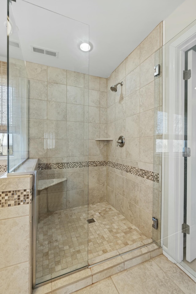 bathroom with tile patterned flooring, a shower stall, and visible vents