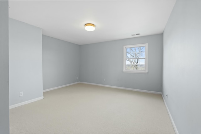 spare room with light carpet, visible vents, and baseboards