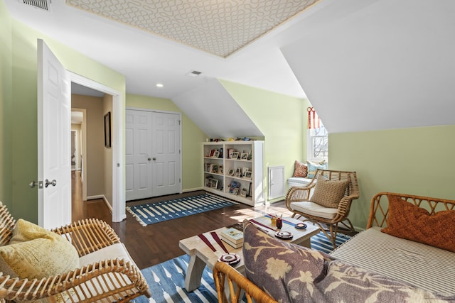 bedroom featuring wood finished floors, baseboards, visible vents, vaulted ceiling, and a closet