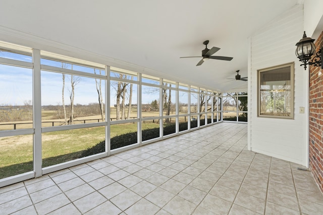 unfurnished sunroom with a rural view, lofted ceiling, and a ceiling fan