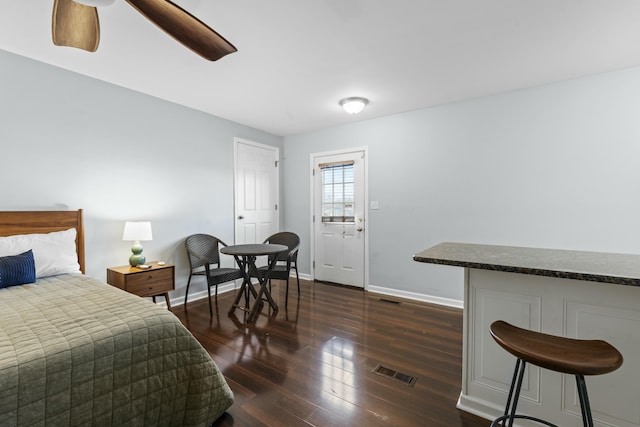 bedroom featuring a ceiling fan, baseboards, visible vents, and dark wood-style flooring