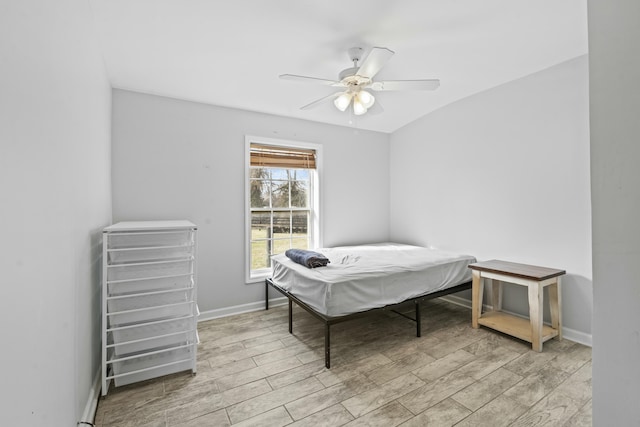 bedroom with a ceiling fan, baseboards, and wood finished floors