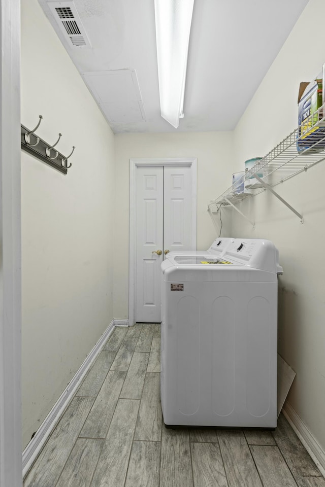 laundry room featuring visible vents, baseboards, wood tiled floor, and laundry area