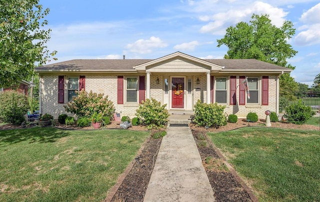 ranch-style home featuring brick siding, a shingled roof, and a front lawn